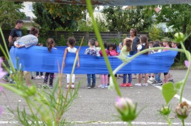 Kinder spielen mit blauem Band